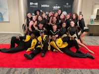 a group of dancers posing on a red carpet