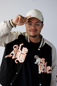 a man in a baseball jacket is posing for a picture